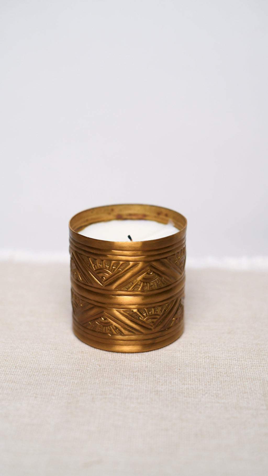 Decorative candle in a brass holder on a white background
