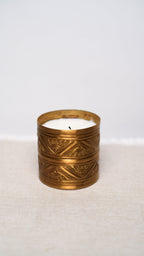 Decorative candle in a brass holder on a white background
