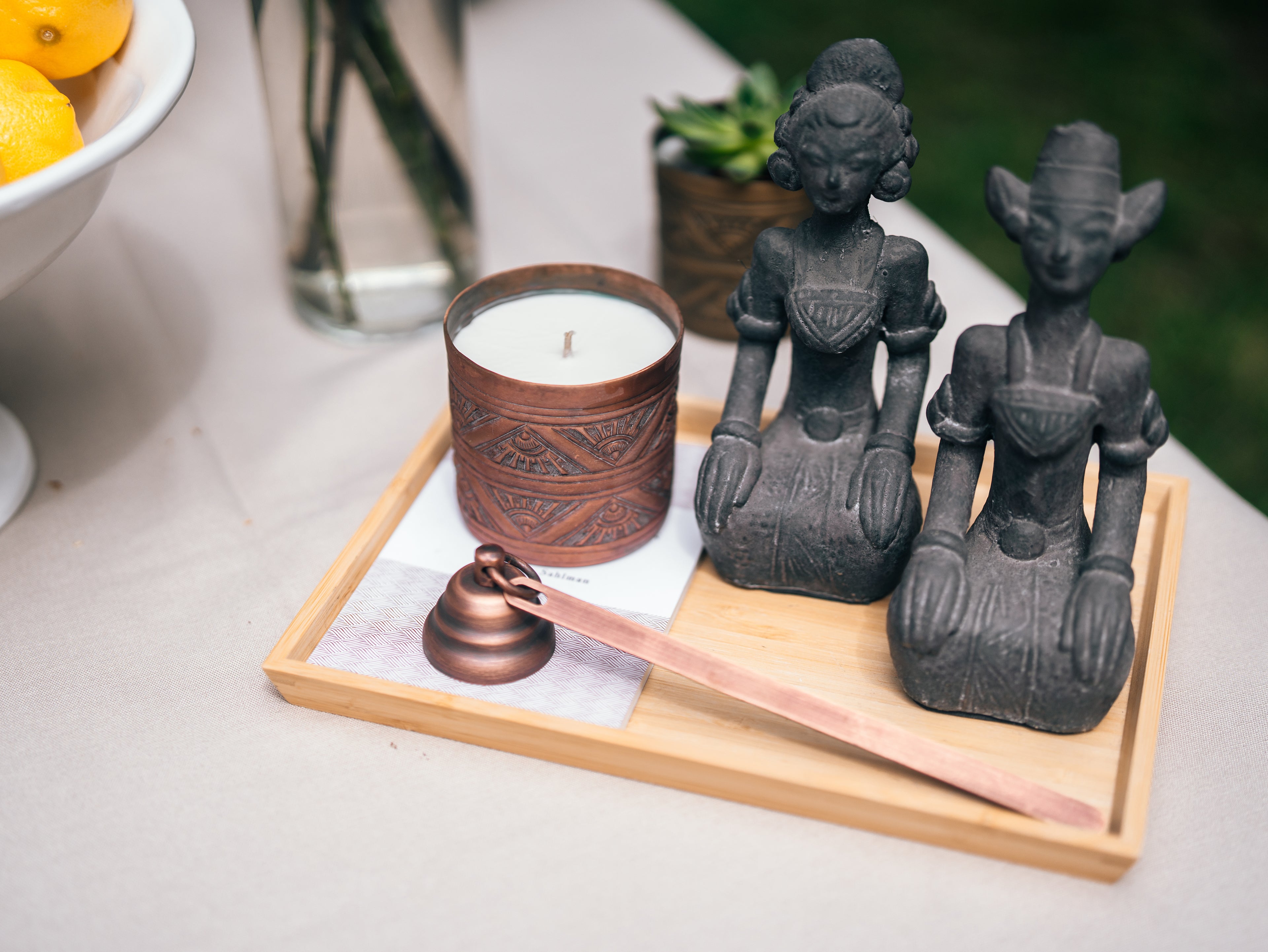 Decorative items including a candle, statues, and a brush on a wooden tray.