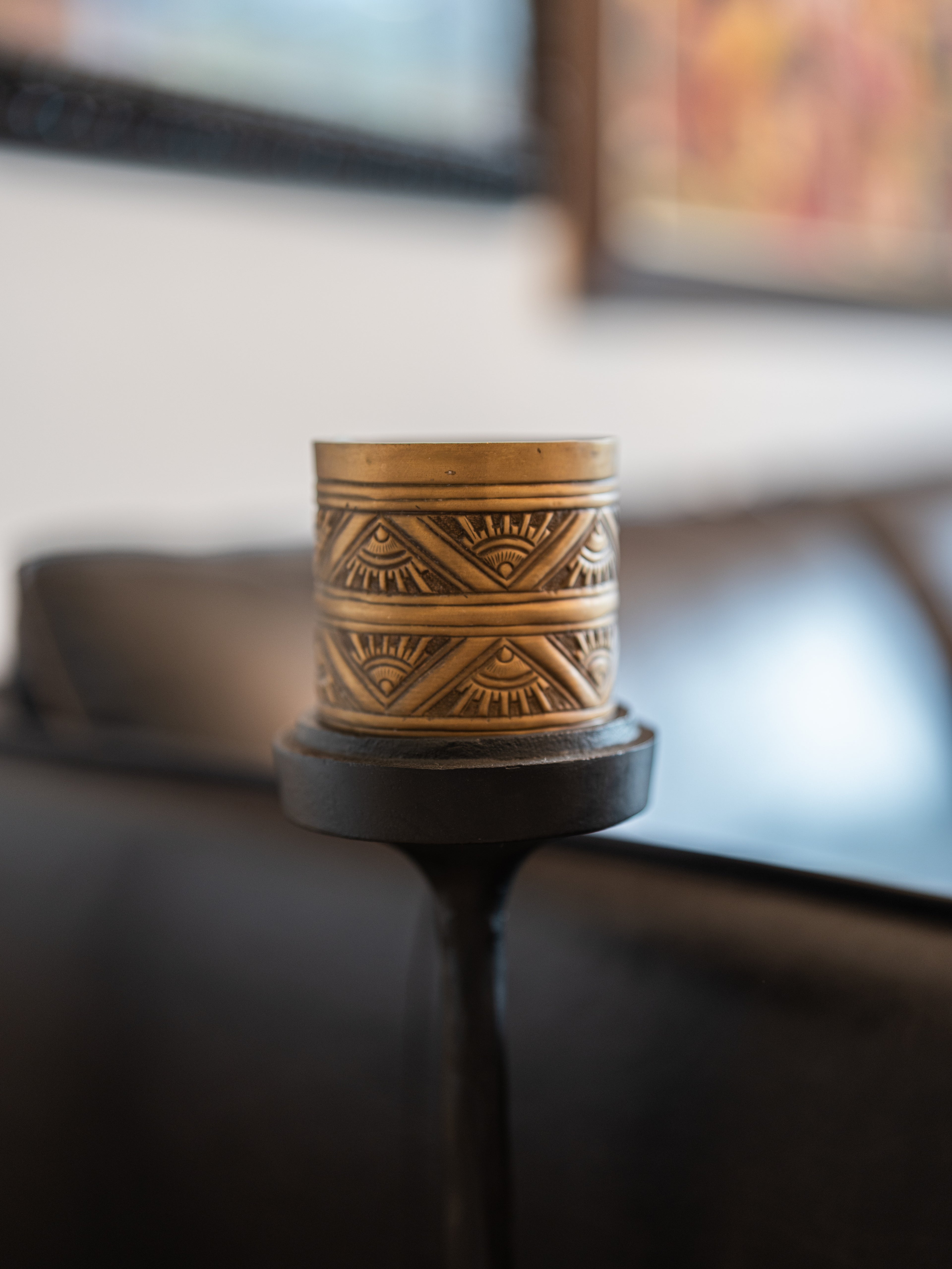 Decorative candle holder with geometric patterns on a blurred background
