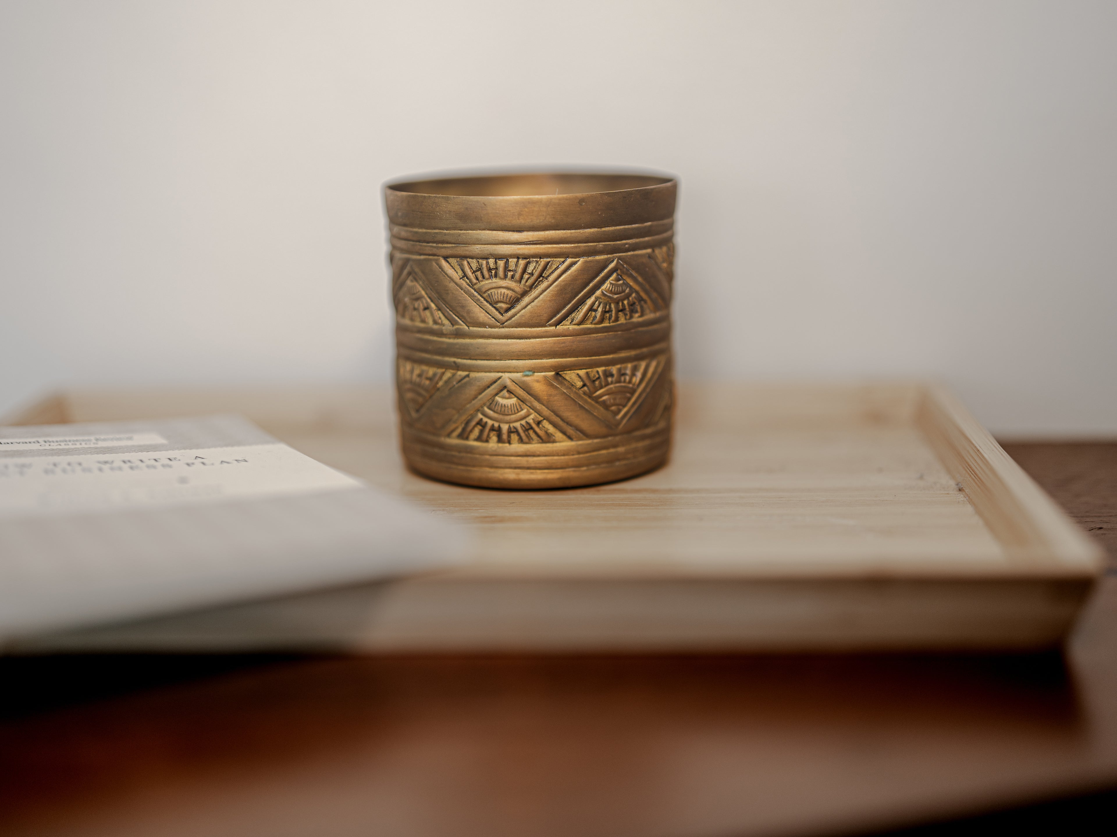 Brass decorative container on a wooden surface with a blurred background